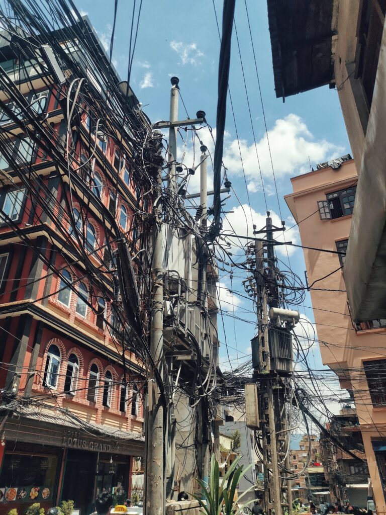 Eine Straßenecke mit zwei Masen, die voller Kabel hängen